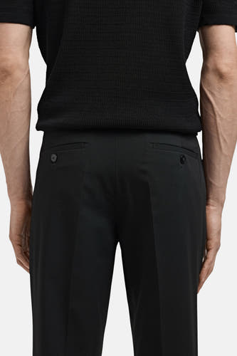 Pantalon de costume noir MANGO, vu de l'arrière avec des poches à boutons.