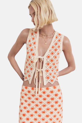 Jupe courte multicolore de MANGO, avec un motif tricoté de fleurs orange et une chemise coordonnée.
