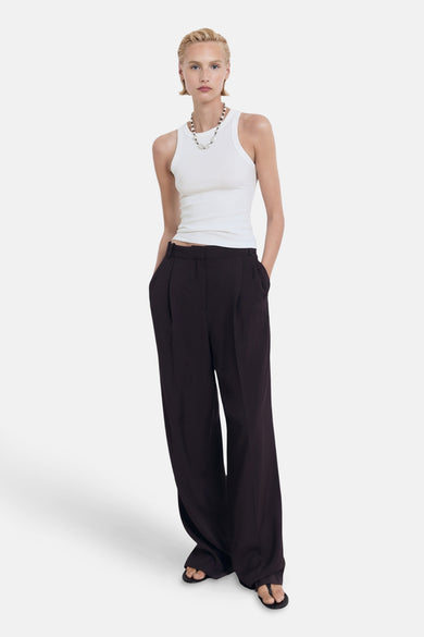 T-shirt blanc de MANGO porté avec un pantalon large marron foncé et une chaîne de perles.