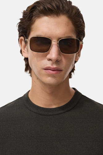 T-shirt noir à manches courtes de MANGO, porté par un homme avec un t-shirt sombre et un chapeau de soleil.