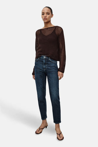 Jean mom bleu marine de MANGO, associé à une chemise marron et des sandales compensées.