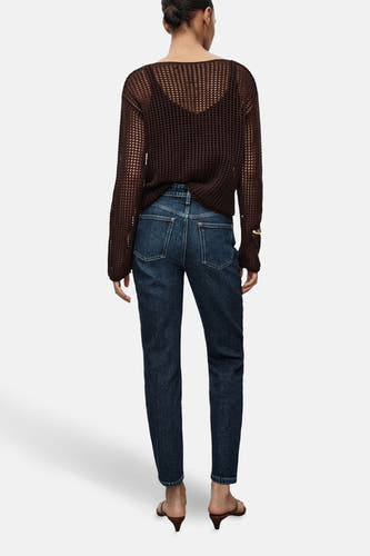Jean mom bleu marine de MANGO, vu de l'arrière, combiné avec une chemise marron et des talons.