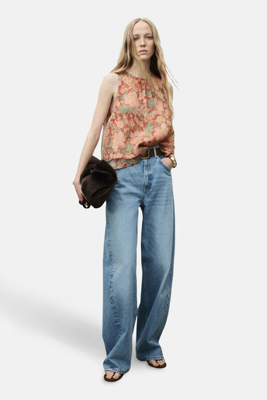 Blouse multicolore sans manches de MANGO, avec un imprimé fleuri et associée à des jeans larges et des accessoires marrons.
