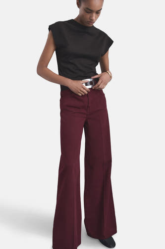 Jean de couleur bordeaux de MANGO, avec des jambes larges et des passants argentés.