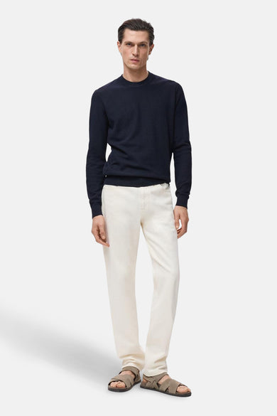 T-shirt bleu avec col rond de MANGO, porté avec un short blanc et des sandales.