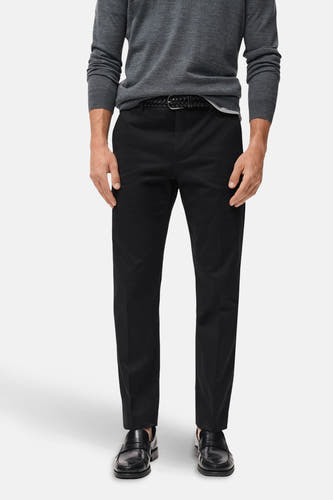 Pantalon bleu marine de MANGO, avec une subtile texture, associé à un pull gris et des chaussures noires.