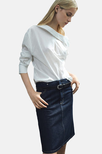 Jupe en denim bleu marine de MANGO, avec une ceinture noire et une couture verticale.