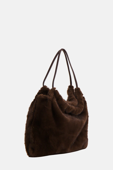 Veste épaulette de MANGO, avec une douce texture et portée avec des escarpins beige et un pantalon.