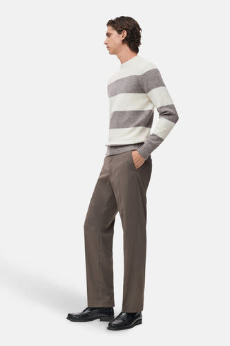 Sweat-shirt multicolore à col rond de MANGO, avec des rayures horizontales, associé à un pantalon marron et des loafers noirs.
