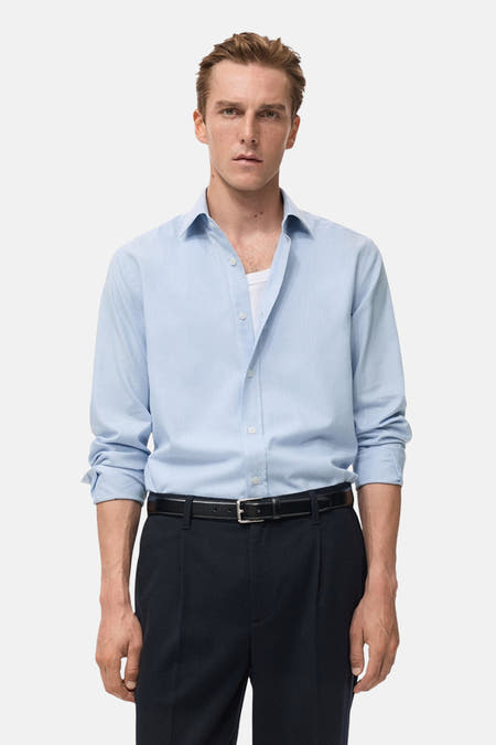 Chemise bleue à manches longues de MANGO, dos, associée à un pantalon noir et des chaussures.
