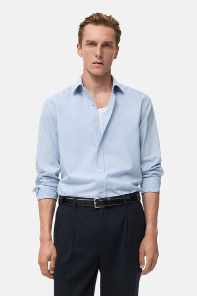 Chemise bleue à manches longues de MANGO, dos, associée à un pantalon noir et des chaussures.