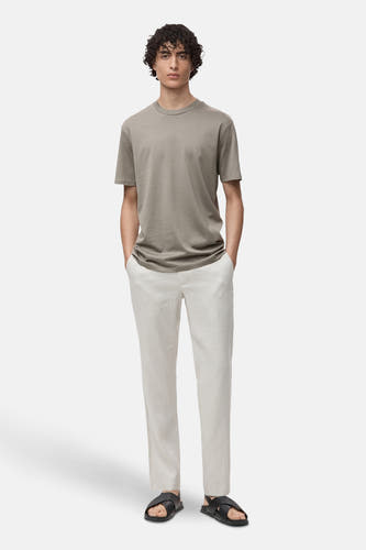 T-shirt gris à manches courtes de MANGO, associé à un short en lin léger et des sandales noires.