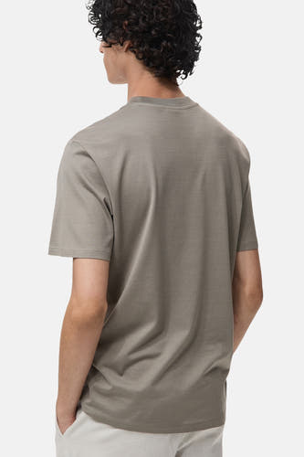 T-shirt gris à manches courtes de MANGO, vu de l'arrière, design uni, associé à un pantalon blanc.