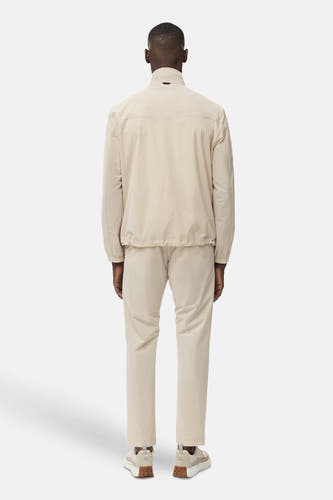 Manteau beige court de MANGO, vue arrière, associé à un pantalon coordonné et des chaussures crème.