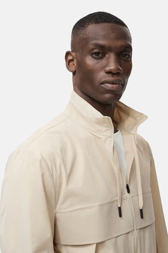 Manteau court beige de MANGO, avec col montant et fermeture éclair devant.