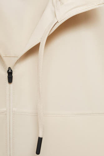 Manteau court beige de MANGO, gros plan avec fermeture éclair et détails de cordon.