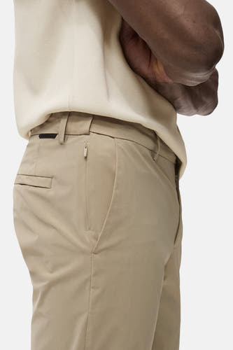 Pantalon beige de MANGO, avec une poche à fermeture éclair sur le côté, en vue latérale.