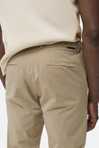 Pantalon beige de MANGO, avec des poches arrière et une subtile texture, partie d'une tenue avec un haut beige.