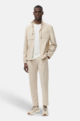 Jean écru de MANGO, avec un modèle décontracté et associé à un T-shirt blanc et une veste coordonnée.