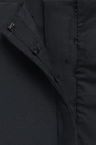 Veste noire de MANGO avec fermeture à glissière et boutons, gros plan.