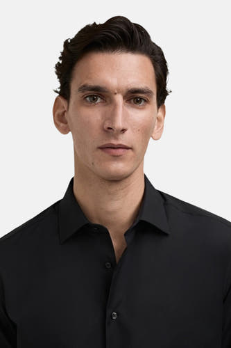 Chemise noire à manches longues de MANGO, gros plan sur un homme qui la porte.