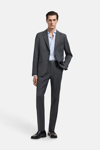 Chemise bleue à manches longues de MANGO, portée sous un manteau gris.