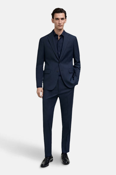 Chemise bleue à manches longues de MANGO, portée avec un pantalon coordonné et des chaussures noires.