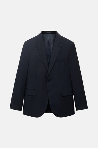 Blazer bleu de MANGO, avec une fermeture à un seul bouton et des poches passepoilées, sur un fond blanc.