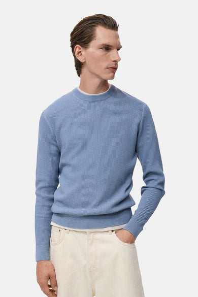 T-shirt bleu avec col rond de MANGO, texture rayée et porté avec des jeans crème.