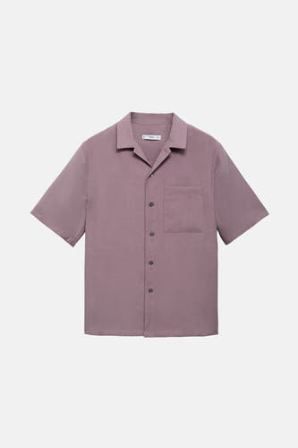 Chemise bleue à manches courtes de MANGO, avec poche poitrine et fermeture à boutons, sur un fond blanc.