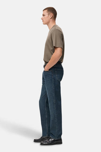 T-shirt kaki à manches courtes de MANGO, porté avec des jeans foncés et des chaussures noires, en vue latérale.