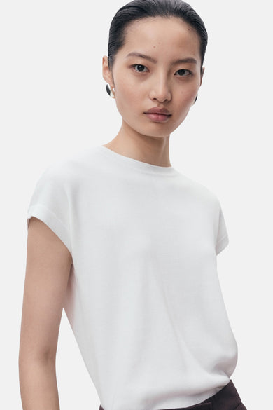 Een model draagt een wit T-shirt.