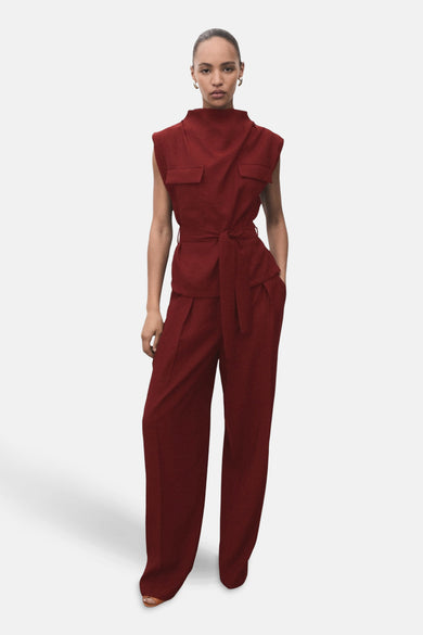 Blouse sans manches Bordeaux de MANGO, avec col montant et ceinture, associée à une jupe coordonnée.