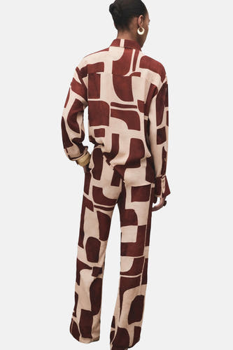 Meerkleurige broek van MANGO, met een bruin en beige abstract geometrisch patroon.
