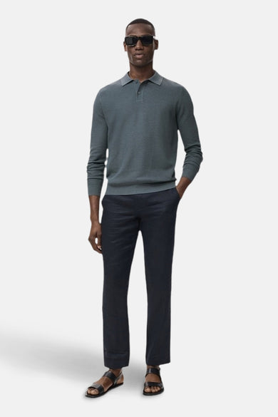 T-shirt vert avec col rond de MANGO, à longues manches et associé à un pantalon foncé et des sandales.
