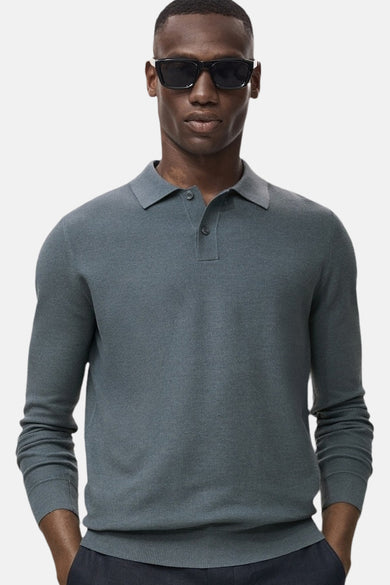 T-shirt vert avec col rond de MANGO, porté avec un pantalon foncé et des lunettes de soleil.