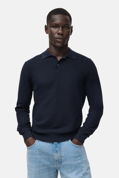 T-shirt bleu avec col rond de MANGO, montré par derrière, associé à un jean bleu clair.