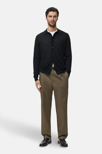 Gilet bleu de MANGO porté sur un T-shirt blanc et un pantalon marron, avec des chaussures noires et une ceinture.