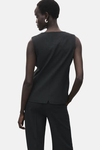 Manteau sans manches gris de MANGO, vu de l'arrière, associé à un pantalon de la même couleur.