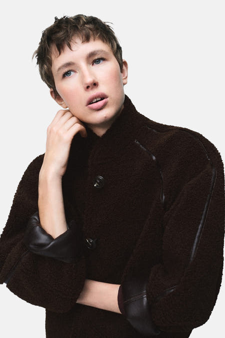 Manteau court brun de MANGO, dos visible, avec une texture lisse et un col ajusté.