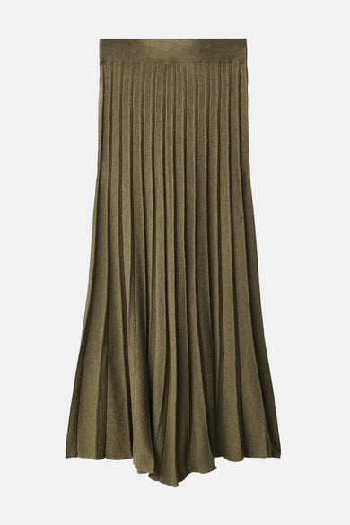 Long pantalon kaki de MANGO, texture froissée, associé à une chemise verte et des gants en cuir noirs.