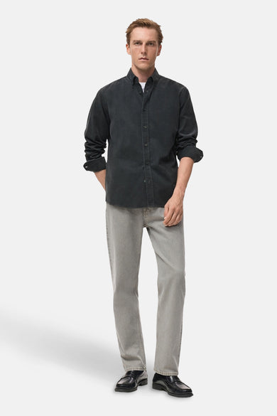 Grijs, lange mouwen overhemd van MANGO, met knoopsluiting, gedragen met een wit T-shirt, grijze jeans en zwarte schoenen.
