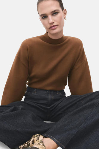 Pull marron avec col montant de MANGO, porté avec des jeans foncés et une chaussure à imprimé serpent.