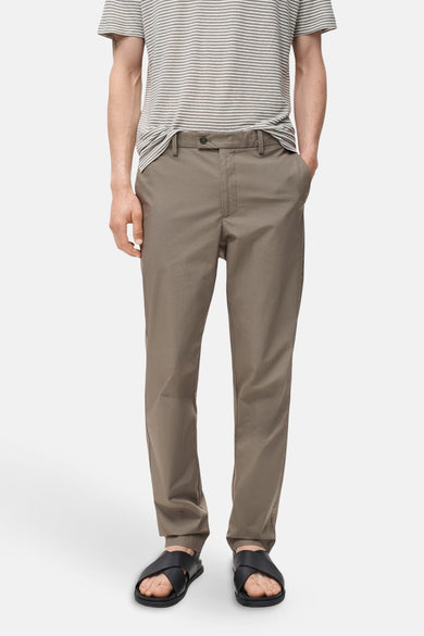 Pantalon marron de MANGO, associé à un t-shirt rayé et des sandales noires.