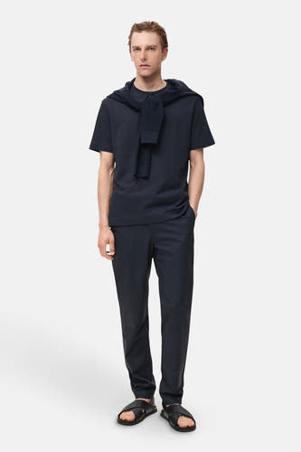 Pantalon bleu de MANGO, associé à un t-shirt bleu marine et des sandales.