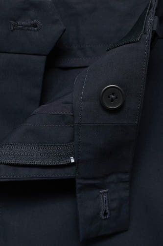 Pantalon bleu de MANGO, gros plan avec fermeture à bouton et fermeture éclair.