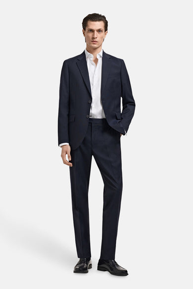 Chemise blanche à manches longues de MANGO, portée sous un manteau bleu marine et des chaussures noires.