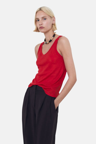 T-shirt rouge de MANGO, associé à un pantalon noir et une chaîne de couleursante.