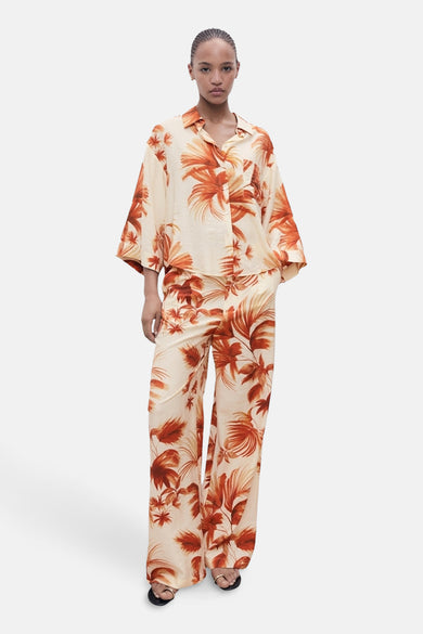 Chemise multicolore à manches courtes de MANGO, avec une impression tropique orange sur un fond crème.