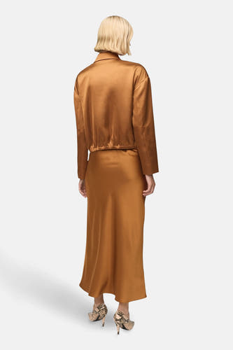 Long manteau de MANGO, vu d'arrière, combiné avec un un et une bottes en cuir de serpent.